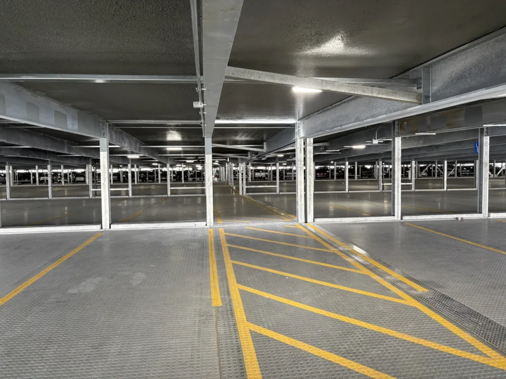 Interior of the Reagan National Airport relocatable parking deck showing galvanized steel framing and marked parking lanes.