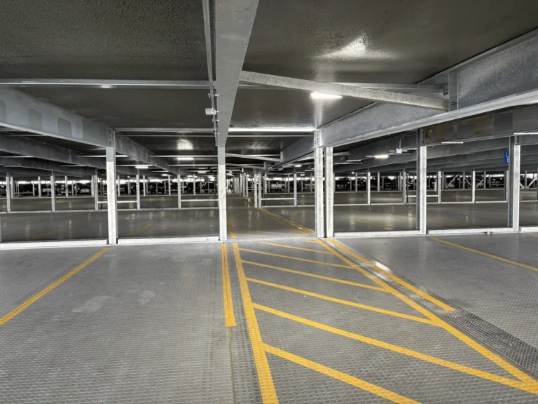 Interior of the Reagan National Airport relocatable parking deck showing galvanized steel framing and marked parking lanes.